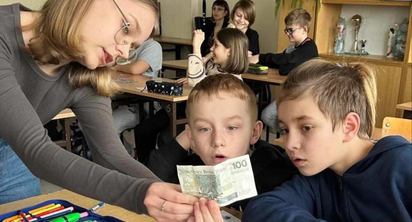 Na zdjęciu młodzież ryckiej dwójki poznająca elementy współczesnego banknotu